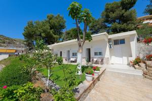 uma casa branca com uma árvore e algumas flores em Flower Vila em Saranda