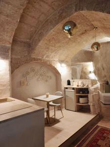 a kitchen with a table and a stove in a room at Stone House in Matera