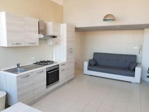 a kitchen with a couch in the middle of it at IRIS Bilocale Centro Città in Busto Arsizio