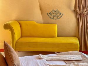 a yellow couch in a room with a sign on the wall at Rum Crystal Luxury Camp in Wadi Rum