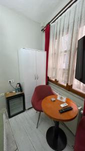 Habitación con mesa, silla roja y TV. en Chez Bore Butique Hotel en Estambul