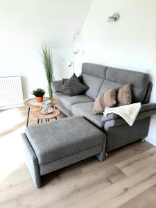 uma sala de estar com um sofá cinzento e uma mesa em Stettiner Straße 7 - Whg 4 em Grömitz