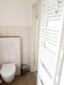 uma casa de banho com um WC branco num quarto em Stettiner Straße 7 - Whg 4 em Grömitz