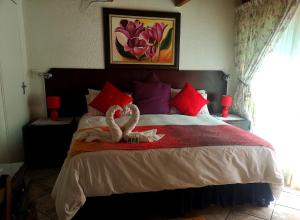 a bedroom with a bed with two swans on it at Elsje's Country Inn in Kempton Park