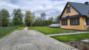 a house with a gravel driveway in front of it at Mościce Dolne 69 in Nowosiółki