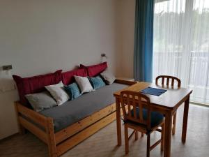 a couch in a living room with a table at Bauernhof-Pension Puschnikhof in Unternarrach
