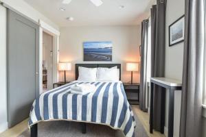 um quarto com uma cama com um cobertor listrado azul e branco em Modern, Private Patio, Walk to Town! em Provincetown