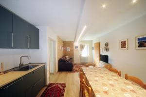 cocina y sala de estar con fregadero y mesa en Appartamento Ginepro, en Ossana