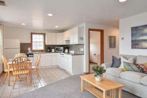 a living room with a couch and a table and a kitchen at 12218 - Beautiful Views of Cape Cod Bay Access to Private Beach Easy Access to P-Town in Truro