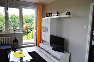ein Wohnzimmer mit einem Flachbild-TV an der Wand in der Unterkunft JTB Apartament Chopina in Stettin