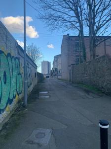 an empty street with graffiti on the side of a wall at Beautiful 2-Bed Apartment in Aberdeen in Aberdeen