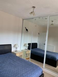 a bedroom with two beds and a mirror with a cat on the wall at Beautiful 2-Bed Apartment in Aberdeen in Aberdeen