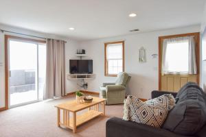 uma sala de estar com um sofá e uma mesa em 12215 - Beautiful Views of Cape Cod Bay Access to Private Beach Easy Access to P-Town em Truro