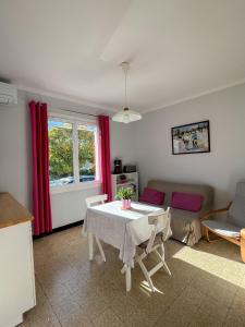uma sala de estar com uma mesa e um sofá em Petit appartement tranquille avec jardin - Hyeres Centre Ville em Hyères