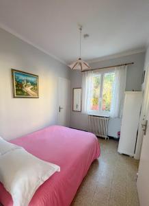 1 dormitorio con cama rosa y ventana en Petit appartement tranquille avec jardin - Hyeres Centre Ville en Hyères