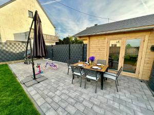 a patio with an umbrella and a table and chairs at Chalet Lasserg in Münstermaifeld