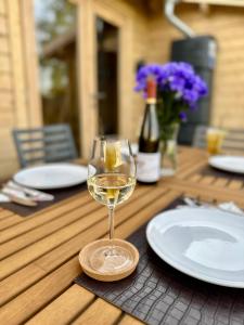 a glass of white wine sitting on a wooden table at Chalet Lasserg in Münstermaifeld