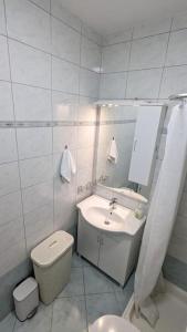 La salle de bains est pourvue d'un lavabo, de toilettes et d'un miroir. dans l'établissement Apartman Natali, à Kaštela