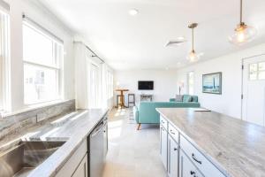 a kitchen with a sink and a living room at Ocean Views Steps to Private Beach A C in Truro +34 photos