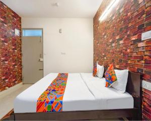 a bedroom with a bed with a brick wall at FabExpress Kings Suites in Bangalore
