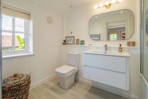 bagno bianco con servizi igienici e specchio di Foxhole Cottage 10 a Stowmarket Altre 39 foto