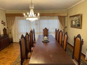 uma sala de jantar com uma mesa longa e um lustre em Cozy Guest House Albergaria em Albergaria-a-Velha