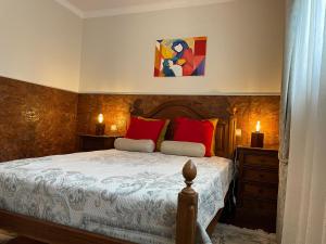 1 dormitorio con 1 cama con almohadas rojas en Cozy Guest House Albergaria en Albergaria-a-Velha