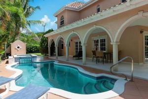 a swimming pool in front of a house at Ocean Pearl Villa in Saint James