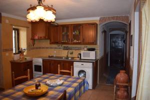 cocina con mesa, fregadero y fogones en Village House in Alto Alentejo, en Arez