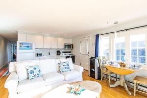 Una sala de estar con un sofá blanco y una mesa. en East End Condo Across from Assoc Beach, en Provincetown