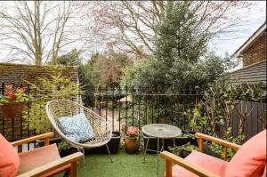 a backyard with chairs and a table and a fence at Georgian house in Billericay - quirky & homely in Billericay