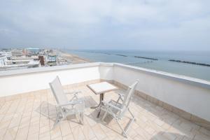 two chairs and a table on a balcony overlooking the ocean at Hotel Capitol in Gatteo a Mare