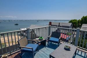 una terraza con 2 sillas y una mesa en la playa en Renovated Oceanfront Penthouse, en Provincetown