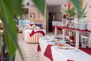 a kitchen with tables with plates and food on them at Hotel Capitol in Gatteo a Mare