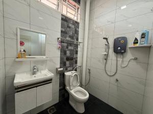 ein Bad mit einem WC und einem Waschbecken in der Unterkunft 126 Homestay TYPE A in Tangkak