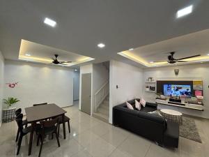 a living room with a black couch and a table at 126 Homestay TYPE A in Tangkak