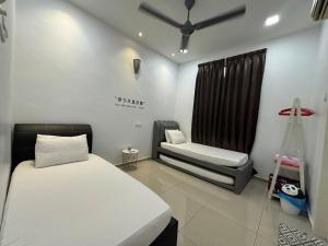 a room with two beds and a chair in it at 126 Homestay TYPE A in Tangkak