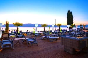 een groep stoelen en tafels op een houten terras bij Park Golden View Hotel Casino in Ohrid