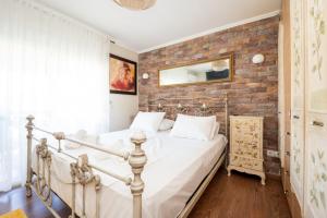 a bed in a room with a brick wall at Villa Natura by RentalsPro Services - Nea Flogita Halkidiki in Flogita