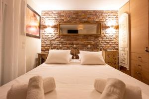 a bedroom with a large white bed with a brick wall at Villa Natura by RentalsPro Services - Nea Flogita Halkidiki in Flogita +70 photos