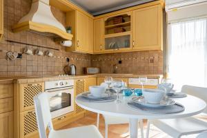 a kitchen with a white table and chairs at Villa Natura by RentalsPro Services - Nea Flogita Halkidiki in Flogita