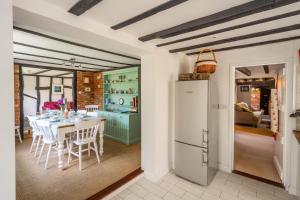 a kitchen and dining room with a table and a refrigerator at Peak Hill Cottage 4 in Theberton
