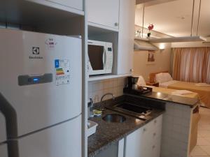 a kitchen with a white refrigerator and a living room at Belo apartamento Perdizes em frente o Allianz Parque com estacionamento in São Paulo
