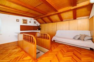 um pequeno quarto com uma cama e piso em madeira em House Sea La Vie em Novi Vinodolski