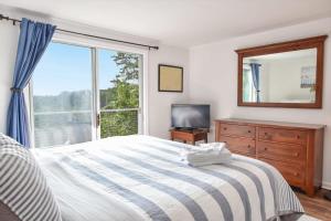 ein Schlafzimmer mit einem Bett und einem großen Fenster in der Unterkunft Marsh Front Home w Sweeping Views in Wellfleet