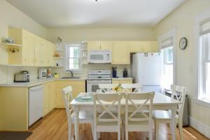 a kitchen with a table and a white refrigerator at Private Downtown Wellfleet Location in Wellfleet +28 photos