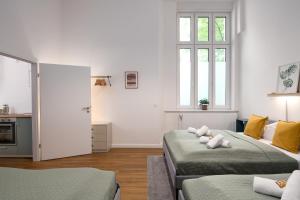 a white room with two beds and a window at Im Herzen von Kreuzberg - perfekt gelegen für bis zu 8 Personen in Berlin