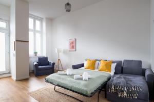 a living room with a blue couch and yellow pillows at Im Herzen von Kreuzberg - perfekt gelegen für bis zu 8 Personen in Berlin