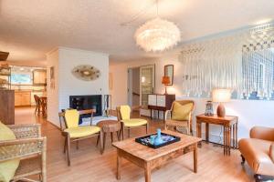 a living room with yellow chairs and a table at Short Walk to Long Pond Swimming Beach in Wellfleet