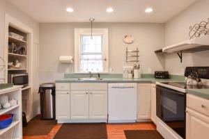 a kitchen with white cabinets and a sink at Walk to Restaurants Shopping & Harbor in Wellfleet